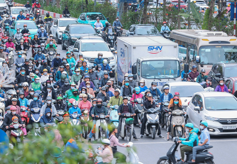 Người dân Hà Nội mặc thêm quần áo ấm khi di chuyển ngoài trời trong sáng 28/10. (Ảnh: Hoàng Hiếu/TTXVN)
