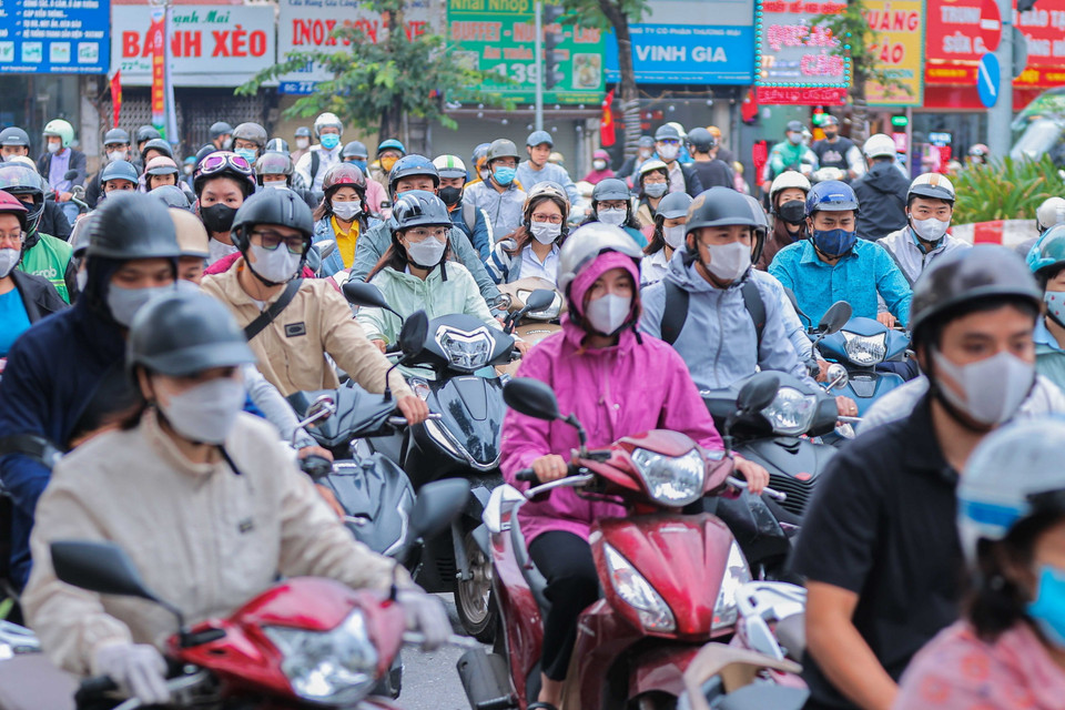 Người dân Hà Nội mặc thêm quần áo ấm khi di chuyển ngoài trời trong sáng 28/10. (Ảnh: Hoàng Hiếu/TTXVN)