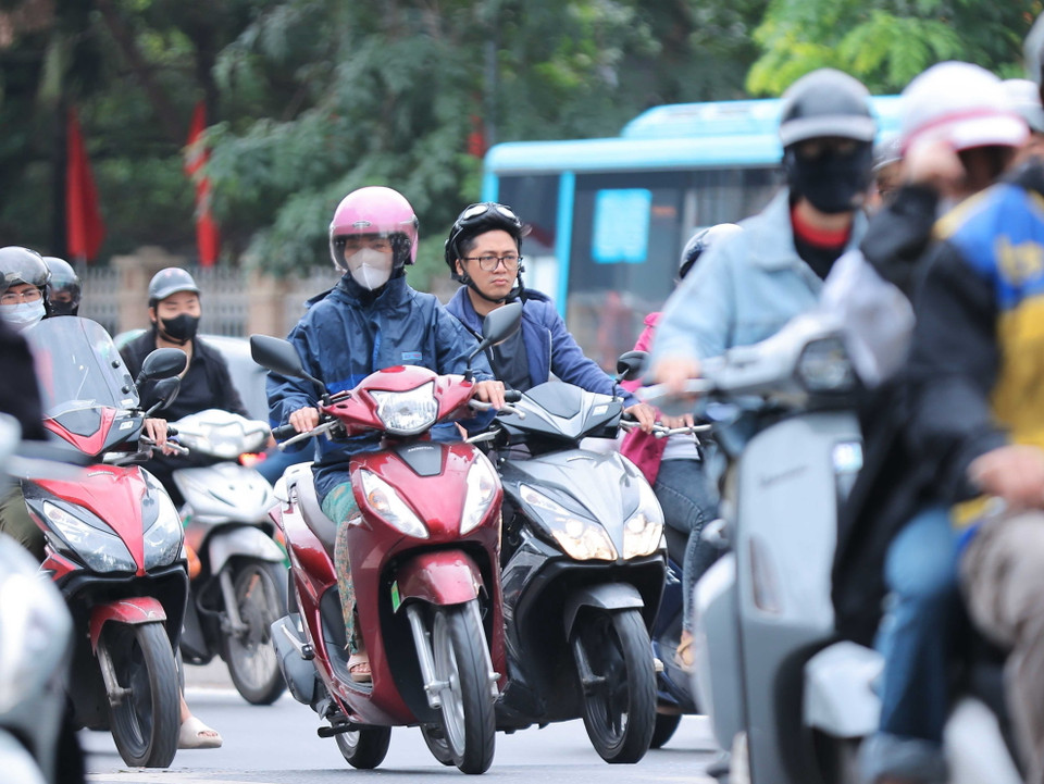 Nhiều người dân Hà Nội đã mặc thêm đồ ấm khi nhiệt độ giảm. (Ảnh: Hoàng Hiếu/TTXVN)