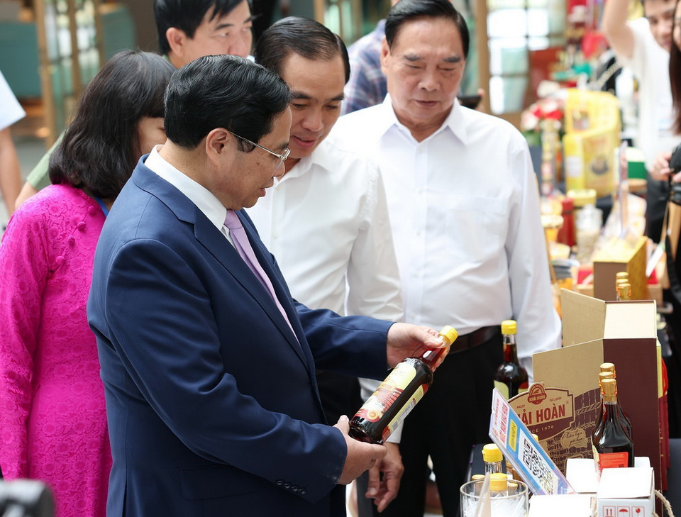 Thủ tướng Phạm Minh Chính xem sản phẩm nghề truyền thống của Phú Quốc. (Ảnh: Dương Giang/TTXVN)