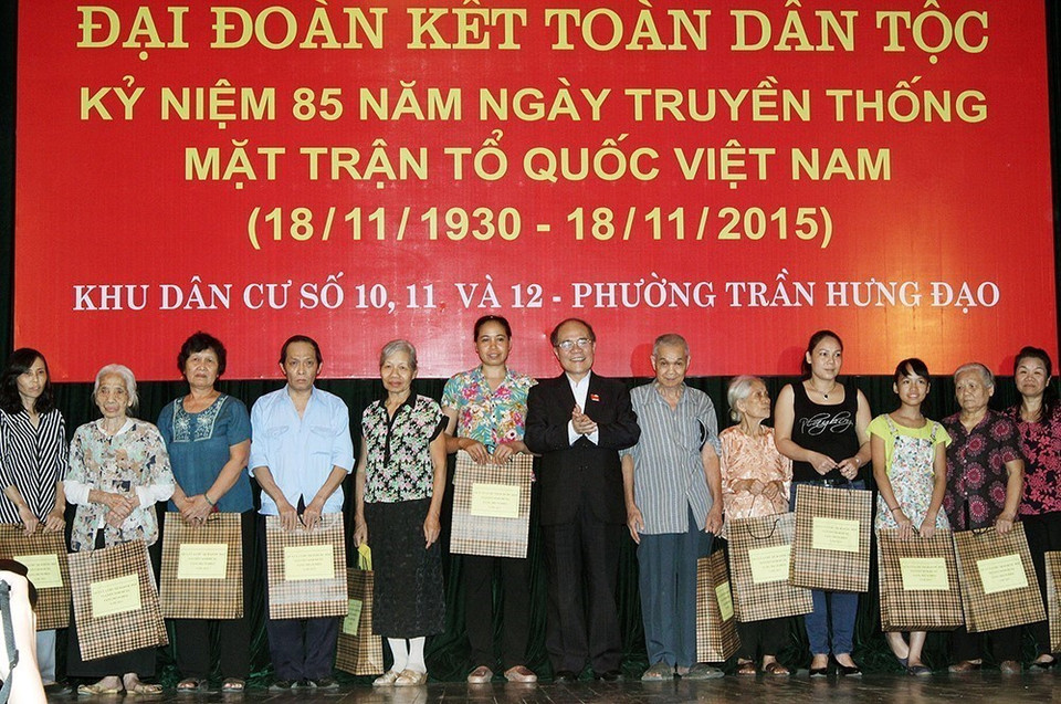 Chủ tịch Quốc hội Nguyễn Sinh Hùng tặng quà cho nhân dân khu dân cư số 10, 11 và 12 tại Ngày hội Đại đoàn kết toàn dân tộc phường Trần Hưng Đạo, Hà Nội (2015). (Ảnh: Nguyễn Dân/TTXVN)