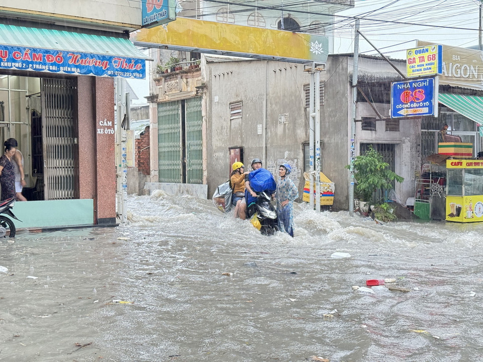 Nước ngập chảy xiết tại khu vực ngã ba Trảng Dài, thành phố Biên Hòa, Đồng Nai khiến người dân di chuyển khó khăn. (Ảnh: Lê Xuân/TTXVN)