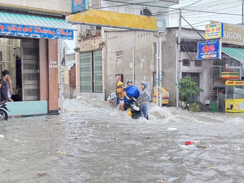 Nước ngập chảy xiết tại khu vực ngã ba Trảng Dài, thành phố Biên Hòa, Đồng Nai khiến người dân di chuyển khó khăn. (Ảnh: Lê Xuân/TTXVN)