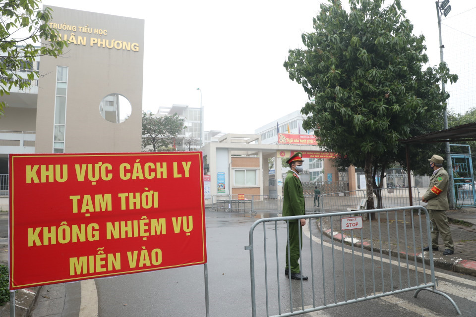 Lực lượng chức năng lập chốt tại cổng trường tiểu học Xuân Phương. (Ảnh: Minh Quyết/TTXVN)