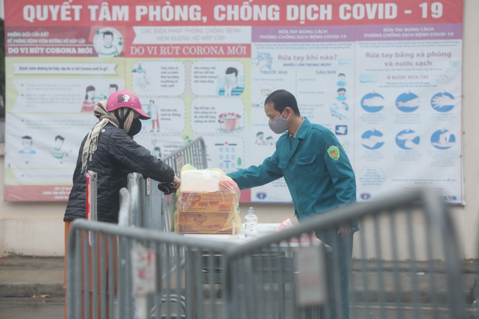 Người nhà gửi đồ tiếp tế cho người bên trong khu cách ly. (Ảnh: Minh Quyết/TTXVN)