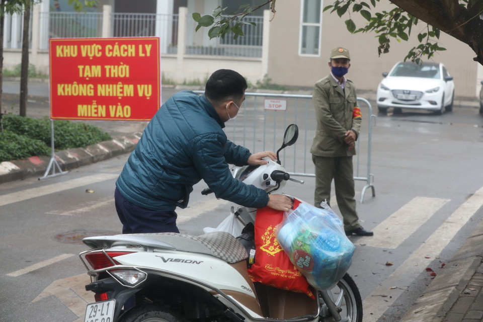 Người nhà gửi đồ tiếp tế cho người bên trong khu cách ly. (Ảnh: Minh Quyết/TTXVN)
