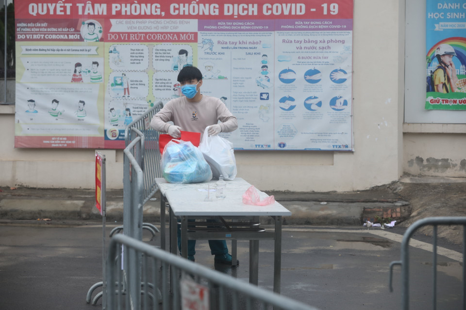 Người nhà gửi đồ tiếp tế cho người bên trong khu cách ly. (Ảnh: Minh Quyết/TTXVN)