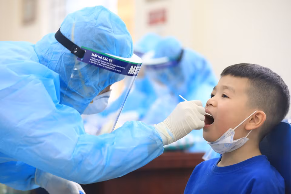 Nhân viên y tế quận Nam Từ Liêm tiến hành hành lấy mẫu xét nghiệm test nhanh COVID-19 cho các em học sinh trường Tiểu học Xuân Phương. (Ảnh: Thành Đạt/TTXVN)