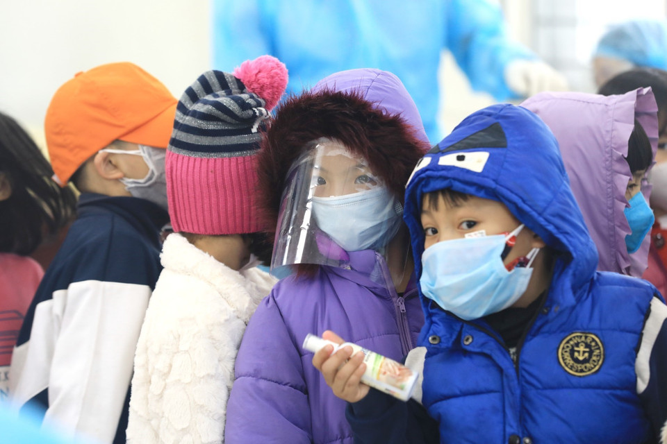 Một em học sinh được bố mẹ trang bị đồ phòng chống dịch rất cẩn thận. (Ảnh: Thành Đạt/TTXVN)