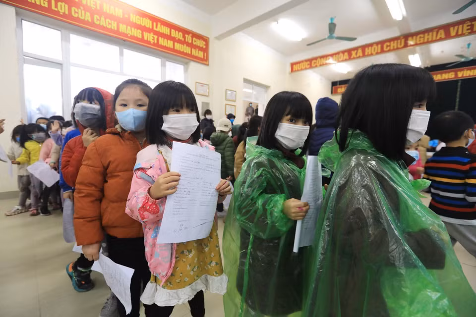 Các em học sinh trường Tiểu học Xuân Phương xếp hàng chờ lấy mẫu xét nghiệm nhanh COVID-19. (Ảnh: Thành Đạt/TTXVN)