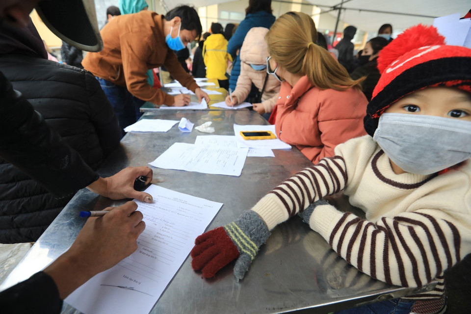 Phụ huynh của các em học sinh trường Tiểu học Xuân Phương đăng ký làm xét nghiệm nhanh COVID-19. (Ảnh: Thành Đạt/TTXVN)