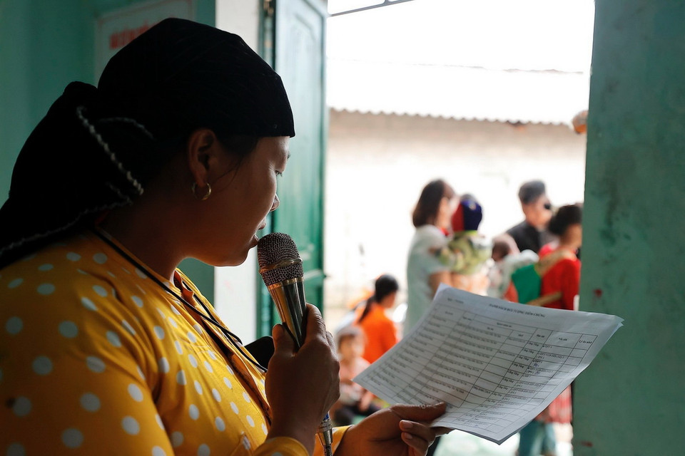 Cô đỡ Mỷ gọi loa thông báo tới các hộ gia đình có trẻ trong độ tuổi đến tiêm vaccine tại nhà văn hóa thôn Cẳng Tằng, xã Lũng Cú, huyện Đồng Văn. (Ảnh: Minh Quyết/TTXVN)