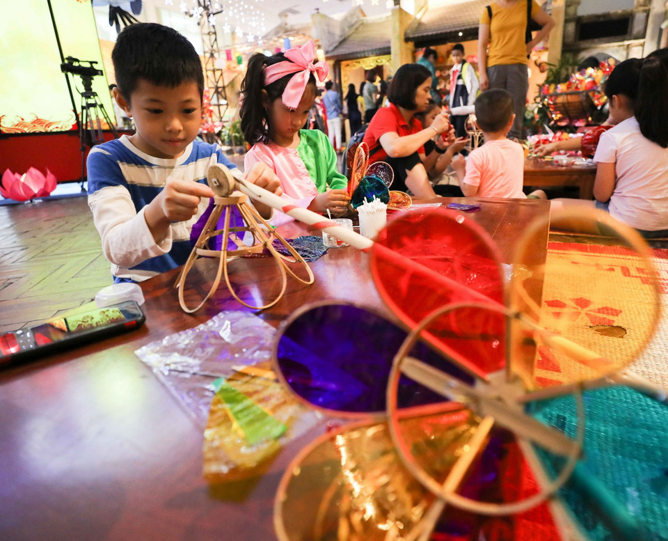 Các em nhỏ được tham gia làm đồ chơi truyền thống với các loại đèn Trung Thu khác nhau. (Ảnh: Thanh Tùng/TTXVN)