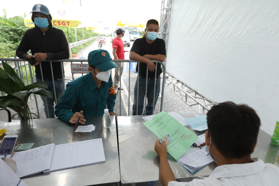 Lực lượng chức năng kiểm tra thông tin, điều kiện của người và phương tiện đi luồng xanh khi qua chốt kiểm soát. (Ảnh: Minh Quyết/TTXVN)