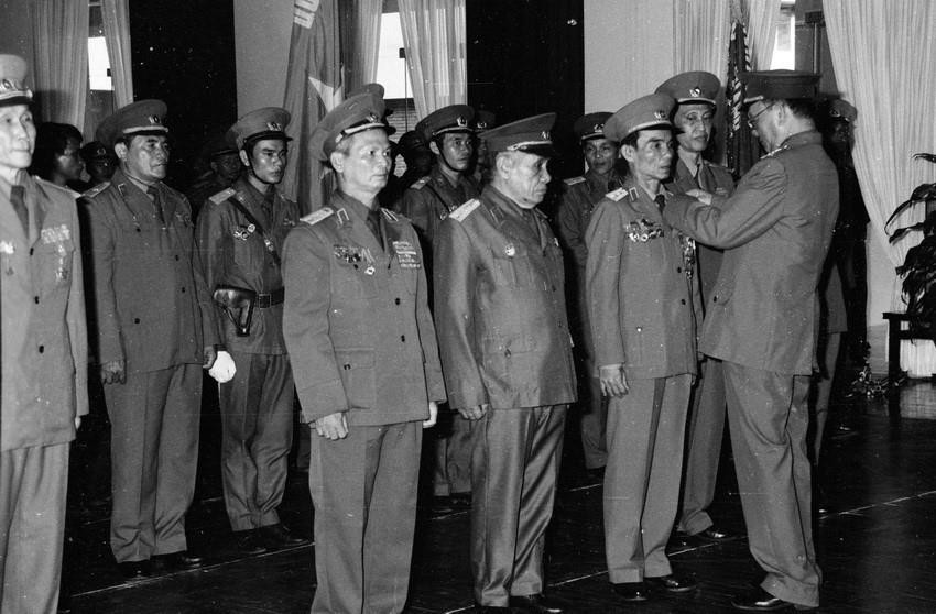 Dưới sự chỉ đạo, chỉ huy của đồng chí Lê Đức Anh, quân tình nguyện và chuyên gia Việt Nam cùng nhân dân Campuchia lật đổ chế độ diệt chủng, tái thiết đất nước Campuchia. Trong ảnh: Đại tướng, Bộ trưởng Quốc phòng Lê Đức Anh trao tặng Danh hiệu Anh hùng lực lượng vũ trang cho 3 đơn vị và trao 8 Huân chương Quân công hạng Nhất cho cán bộ, chiến sỹ và đại diện các gia đình có người thân hy sinh trong khi làm nhiệm vụ quốc tế tại Campuchia. (Ảnh: Minh Điền/TTXVN)