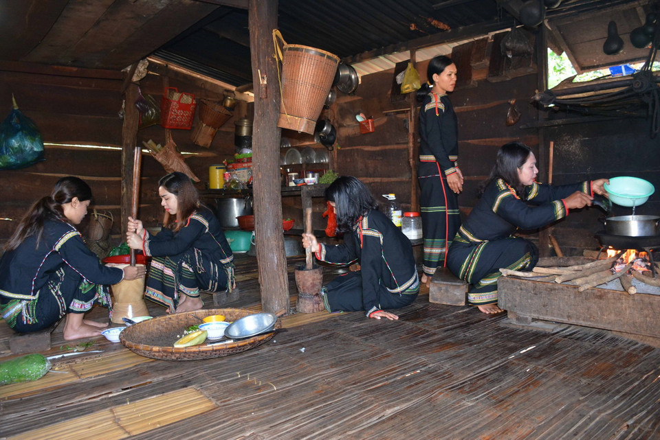 Các cô gái Ê Đê mỗi người một việc để chuẩn bị nguyên liệu nấu món canh bột lá yao. (Ảnh: Hoài Thu/TTXVN)