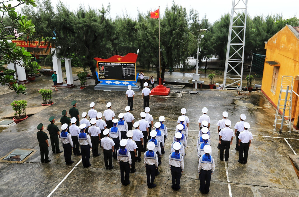 Nghi lễ Chào cờ được thực hiện nghiêm trang hướng tới Đại hội Đảng XIII. (Ảnh: Thành Đạt/TTXVN)