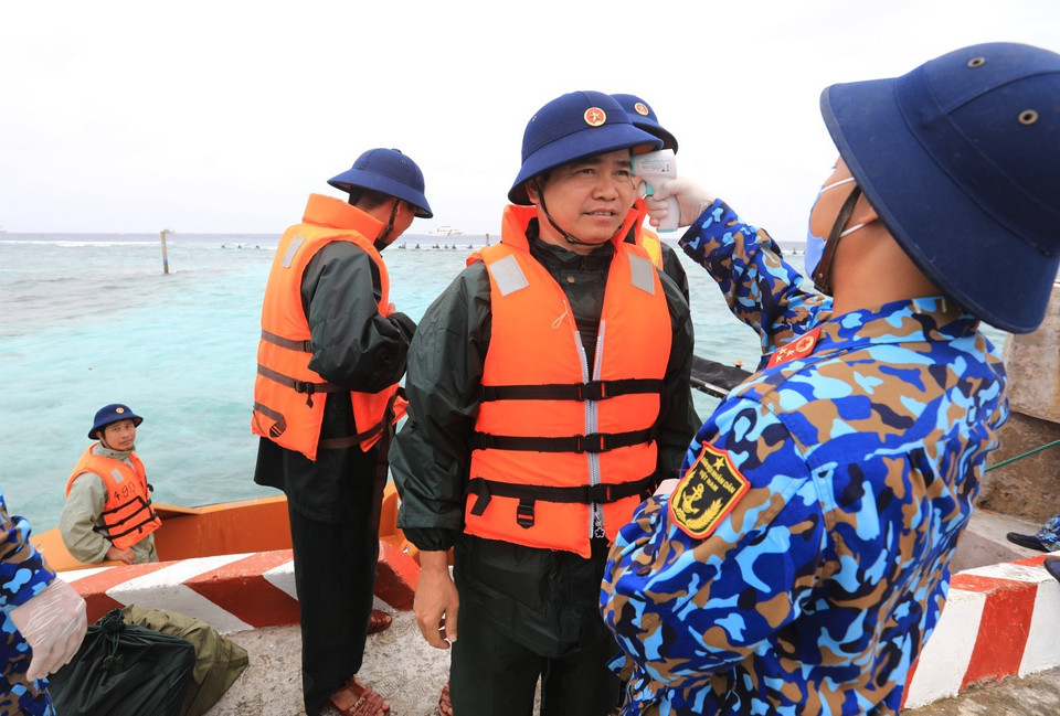 Đoàn công tác Vùng 4 Hải quân thực hiện kiểm tra nhiệt độ và rửa tay sát khuẩn khi lên đảo Sinh Tồn Đông. (Ảnh: Thành Đạt/TTXVN)