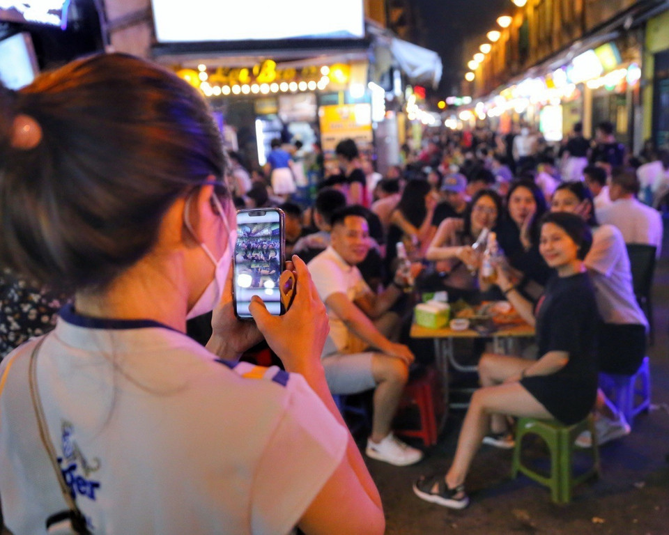 Các bạn trẻ chụp hình lưu niệm tại phố Tạ Hiện. (Ảnh: Tuấn Đức/TTXVN)