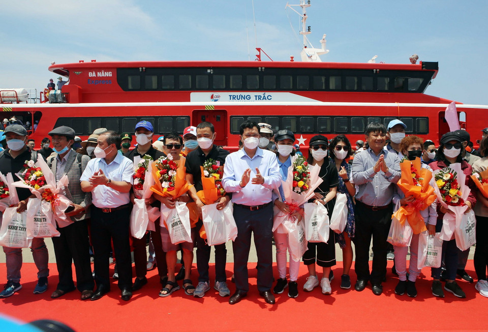 Đại diện lãnh đạo thành phố Đà Nẵng và tỉnh Quảng Ngãi tặng hoa và quà chúc mừng những hành khách đầu tiên đến đảo Lý Sơn trên tuyến đường biển Đà Nẵng-Lý Sơn vừa đưa vào sử dụng. (Ảnh: Trần Lê Lâm/TTXVN)