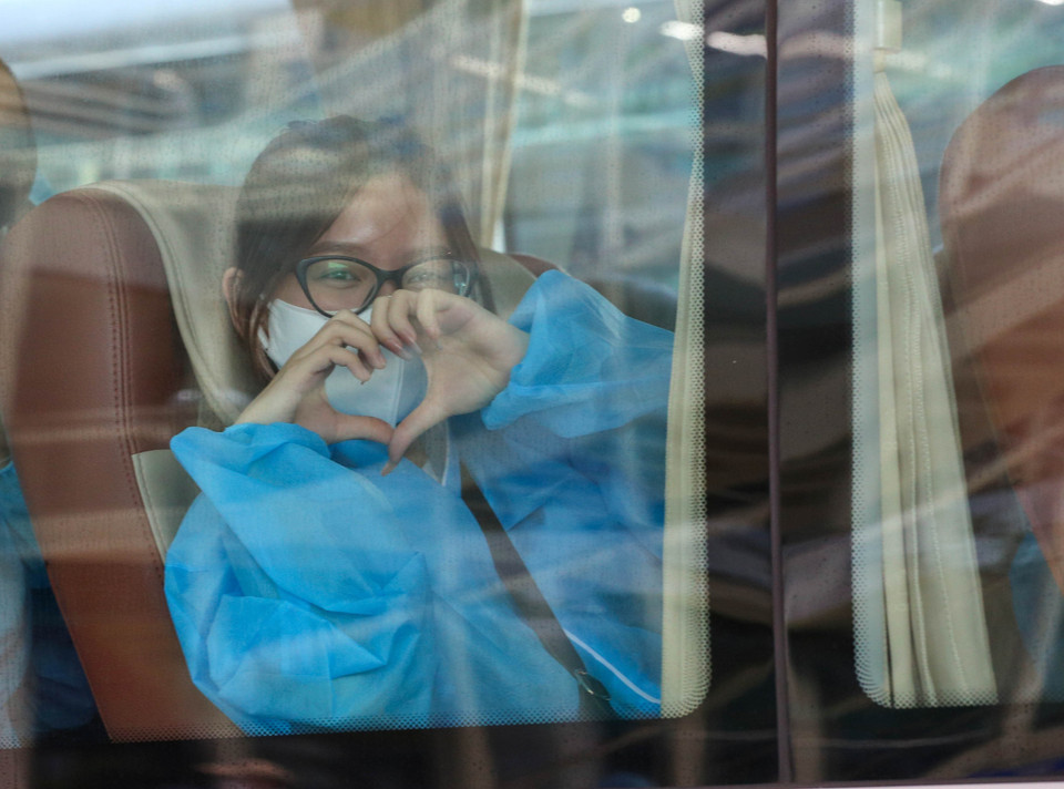 Niềm vui của một cô gái sau khi về tới sân bay Đà Nẵng và lên xe thực hiện cách ly theo quy định. (Ảnh: Trần Lê Lâm/TTXVN)