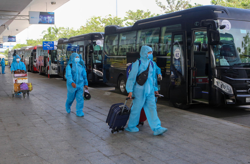 Tại Sân bay Quốc tế Đà Nẵng, các lực lượng chức năng đã túc trực xe ô tô để chờ đón người dân; các công dân xuống sân bay đều mặc đồ bảo hộ, đeo khẩu trang, thực hiện giãn cách và lên 11 xe ôtô để về 3 nơi cách ly tại các khách sạn là The Code; Risemount; Pandora trên địa bàn Đà Nẵng. (Ảnh: Trần Lê Lâm/TTXVN)