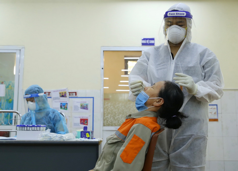  Nhân viên y tế lấy mẫu xét nghiệm cho người dân phường Nguyễn Trãi (Hà Đông) sáng 19/8. (Ảnh: Hoàng Hiếu/TTXVN)