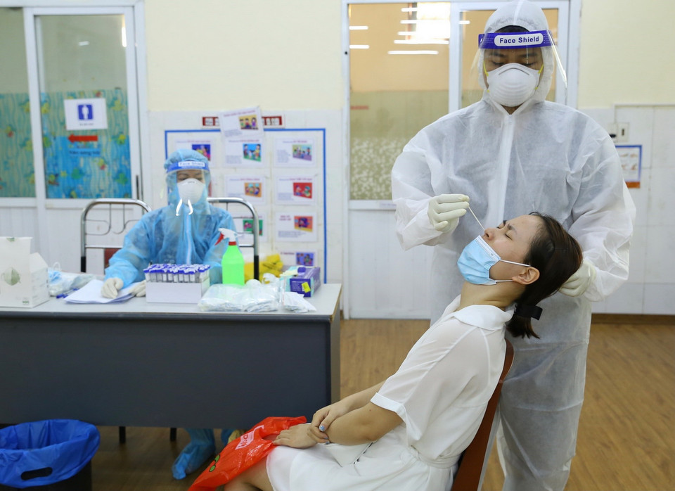  Nhân viên y tế lấy mẫu xét nghiệm cho người dân phường Nguyễn Trãi (Hà Đông) sáng 19/8. (Ảnh: Hoàng Hiếu/TTXVN)