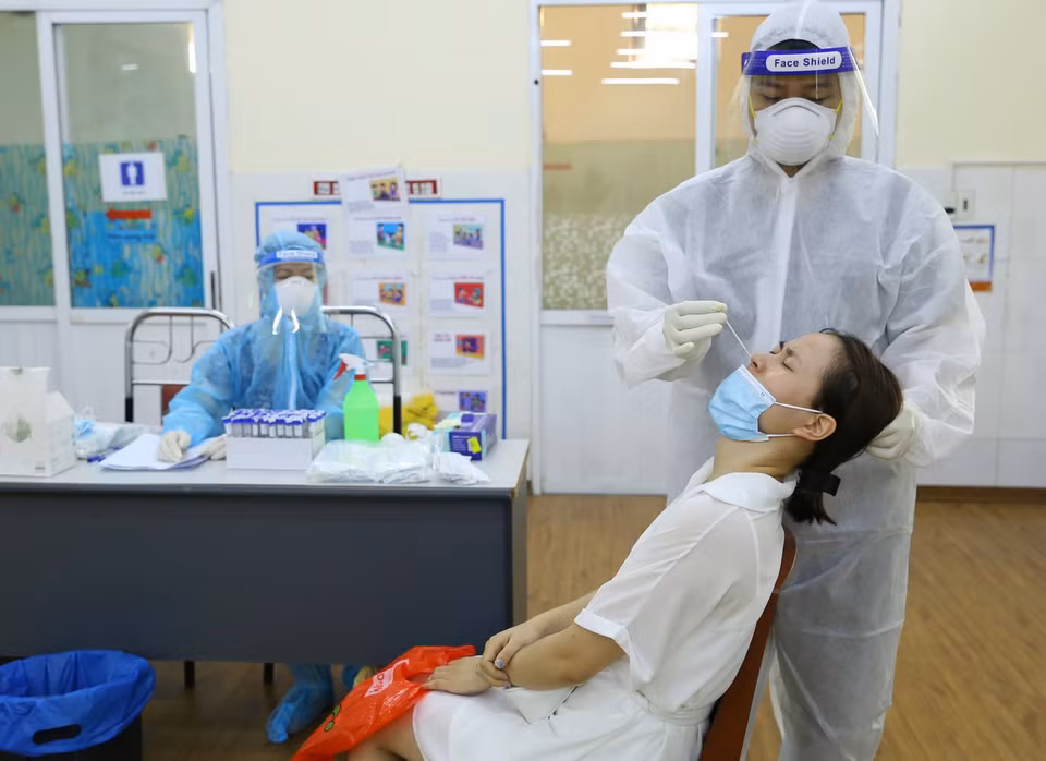  Nhân viên y tế lấy mẫu xét nghiệm cho người dân phường Nguyễn Trãi (Hà Đông) sáng 19/8. (Ảnh: Hoàng Hiếu/TTXVN)