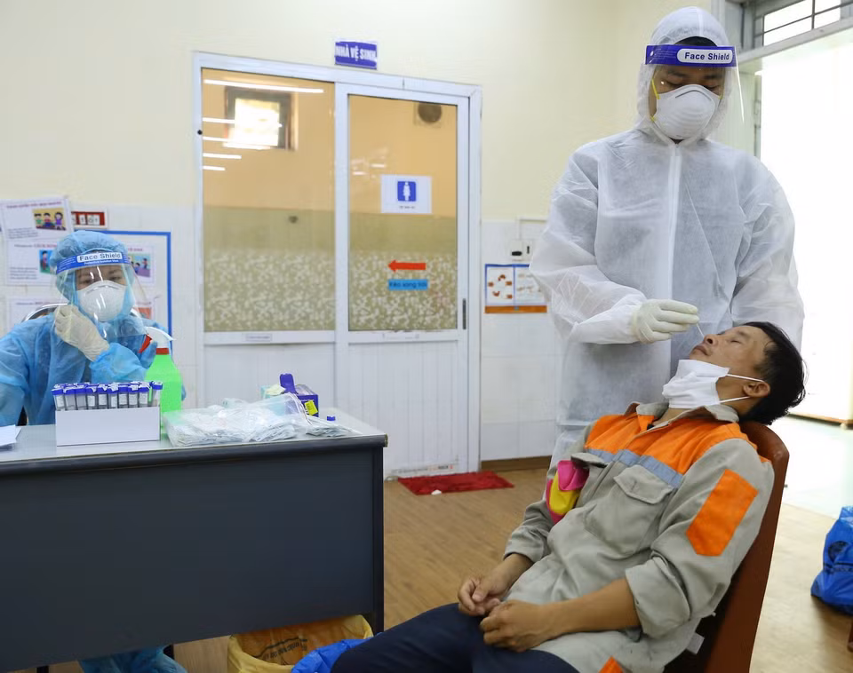  Nhân viên y tế lấy mẫu xét nghiệm cho người dân phường Nguyễn Trãi (Hà Đông) tại điểm Trường mầm non 3/2 sáng 19/8. (Ảnh: Hoàng Hiếu/TTXVN)