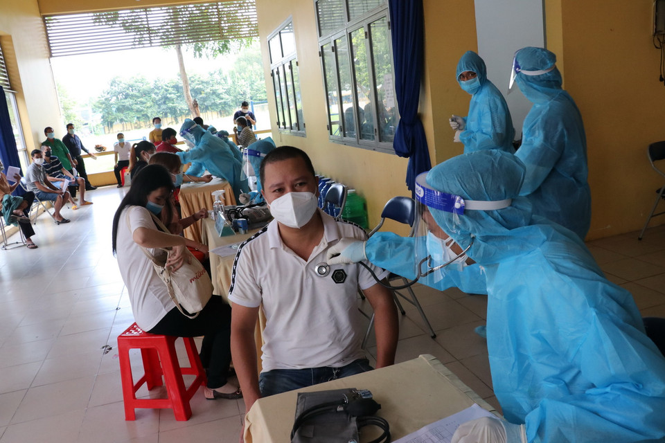 Người dân được kiểm tra sức khỏe trước khi tiêm vaccine Vero Cell tại điểm tiêm Trung tâm văn hóa phường Phú Lợi, thành phố Thủ Dầu Một, tỉnh Bình Dương. (Ảnh: Chí Tưởng/TTXVN) 