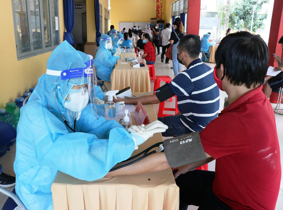 Người dân được kiểm tra sức khỏe trước khi tiêm vaccine Vero Cell tại điểm tiêm Trung tâm văn hóa phường Phú Lợi, thành phố Thủ Dầu Một, tỉnh Bình Dương. (Ảnh: Chí Tưởng/TTXVN) 