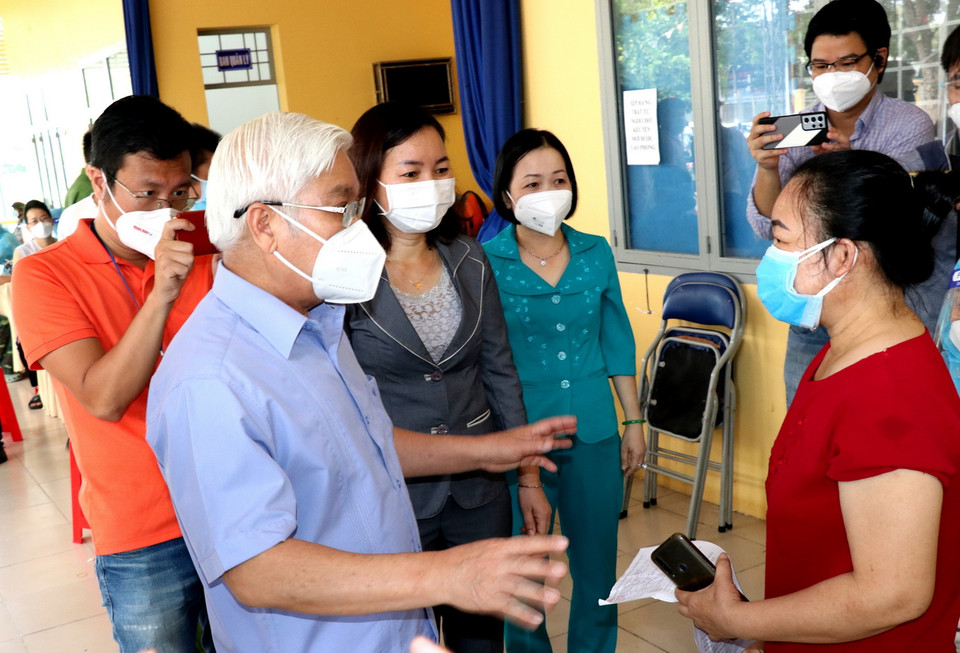 Bí thư Tỉnh ủy Bình Dương Nguyễn Văn Lợi trao đổi với người dân tại điểm tiêm ở Trung tâm văn hóa phường Phú Lợi, thành phố Thủ Dầu Một. (Ảnh: Chí Tưởng/TTXVN) 