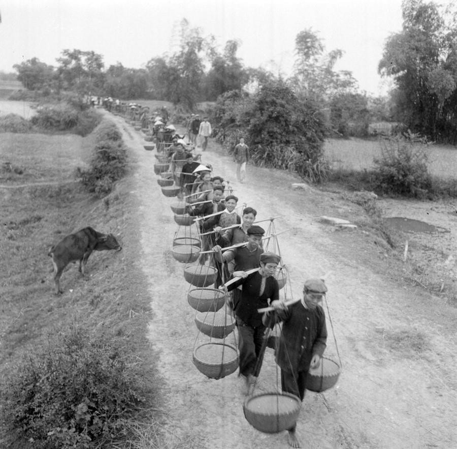 Giai đoạn 1954-1960, công tác tuyên giáo đóng vai trò trọng yếu trong việc khơi dậy ý chí, tri thức và sức mạnh trong quần chúng, cổ vũ mạnh mẽ các phong trào thi đua như Gió Đại Phong, Sóng Duyên Hải, Tiếng trống Bắc Lý, Cờ Ba nhất… Trong ảnh: Xã viên HTX Thái Hòa, xã Hợp Đồng, huyện Chương Mỹ, tỉnh Hà Đông bán thóc thừa cho nhà nước trong vụ mùa 1960. (Ảnh: Tôn Mẫn/TTXVN)
