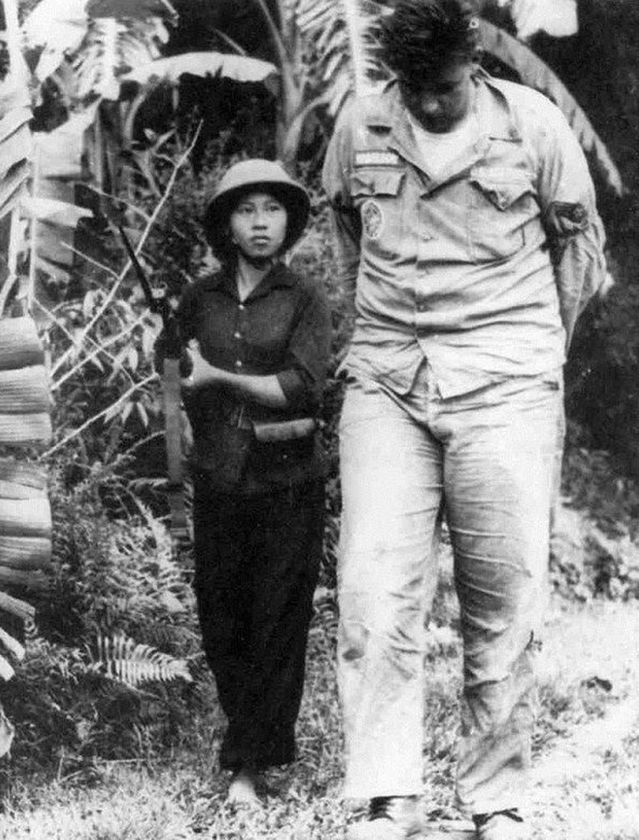 Suốt 10 năm (1965-1975), công tác tuyên giáo đã góp phần quan trọng trong việc động viên quân dân miền Bắc chuyển hướng xây dựng kinh tế sang thời chiến, vừa sản xuất, vừa chiến đấu, đánh thắng cuộc chiến tranh phá hoại của Mỹ và tích cực chi viện cho miền Nam. Trong ảnh: Phi công Mỹ William Andrew Robinson bị bắt và được áp giải bởi nữ dân quân Nguyễn Thị Kim Lai khi máy bay bị bắn rơi tại thị trấn Hương Khê, tỉnh Hà Tĩnh, đêm 20/9/1965. (Ảnh: Phan Thoan/TTXVN)