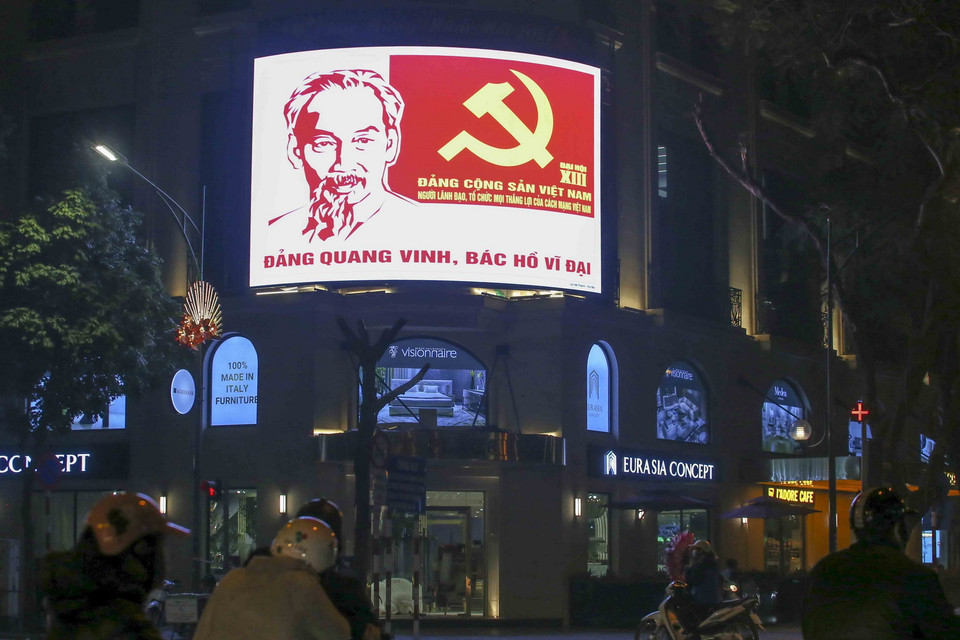 Vào buổi tối, một số tòa nhà cho bật các pano điện tử với khẩu hiệu chào mừng Đại hội XIII của Đảng. (Ảnh: Tuấn Đức/TTXVN)