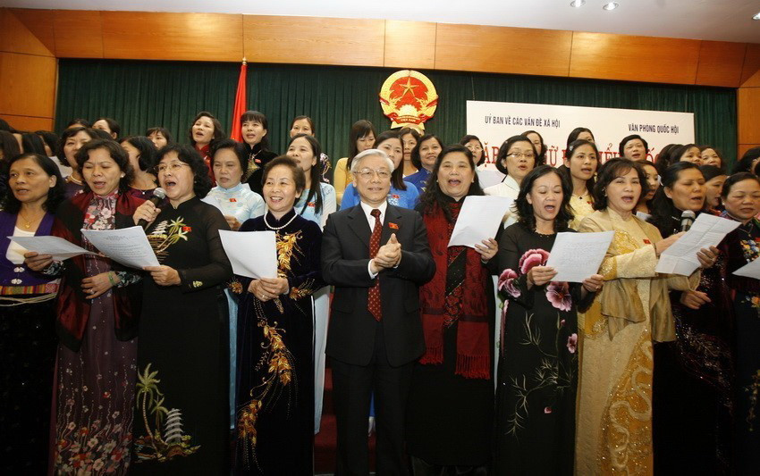  Chủ tịch Quốc hội Nguyễn Phú Trọng tham gia văn nghệ với các nữ đại biểu Quốc hội nhân Ngày phụ nữ Việt Nam năm 2009. (Ảnh: Thái Bình/TTXVN)