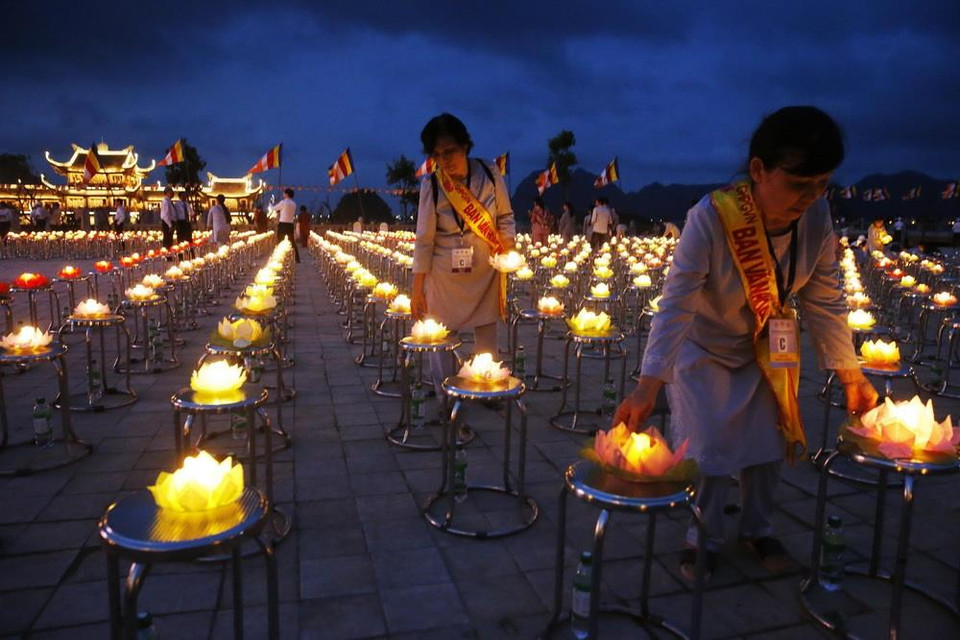 Các Phật tử thắp nến chuẩn bị Đại lễ. (Ảnh: Thành Đạt/TTXVN)