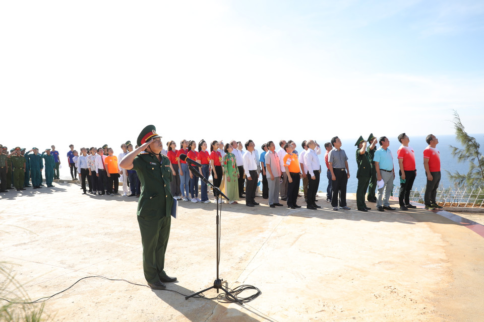 Các đại biểu thực hiện nghi lễ chào cờ khi lá cờ được kéo lên. (Ảnh: Lâm Phan/Vietnam+)
