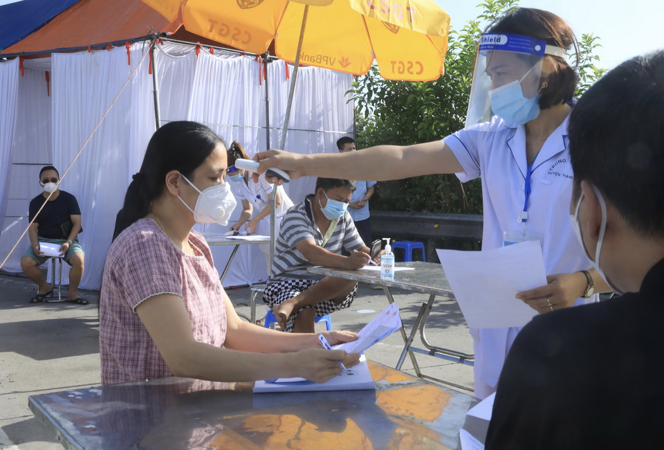 Lực lượng y tế kiểm tra thân nhiệt với những người đến từ vùng dịch. (Ảnh: Lâm Khánh/TTXVN)