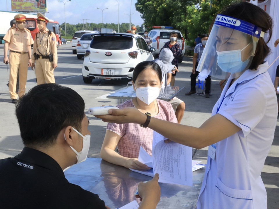 Kiểm tra thân nhiệt với những người đến từ vùng dịch. (Ảnh: Lâm Khánh/TTXVN)