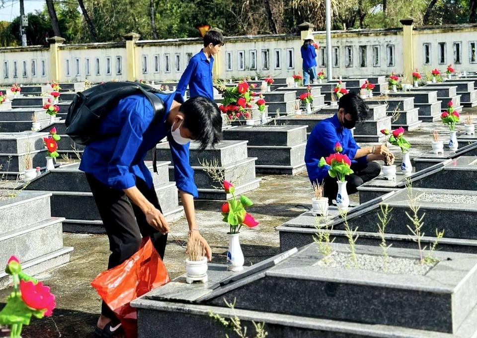 Đoàn viên thanh niên sửa sang, làm mới phần mộ các Anh hùng liệt sỹ tại nghĩa trang liệt sỹ các địa phương của tỉnh Quảng Nam. (Ảnh: TTXVN phát)