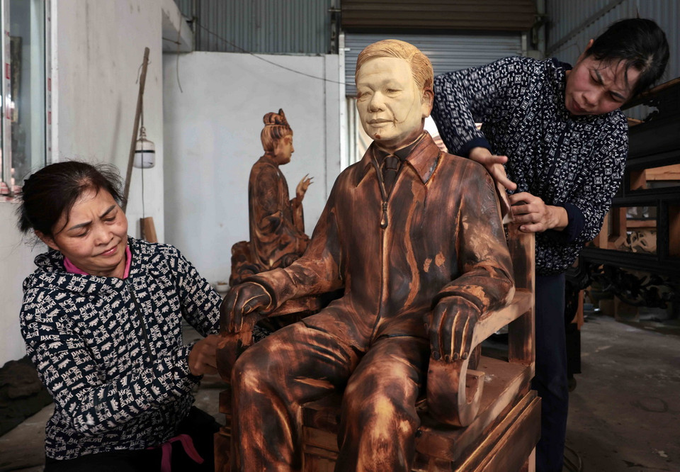 Các nghệ nhân đang hoàn thiện bức tượng cố Tổng Bí thư Nguyễn Phú Trọng. (Ảnh: Trần Việt/TTXVN)