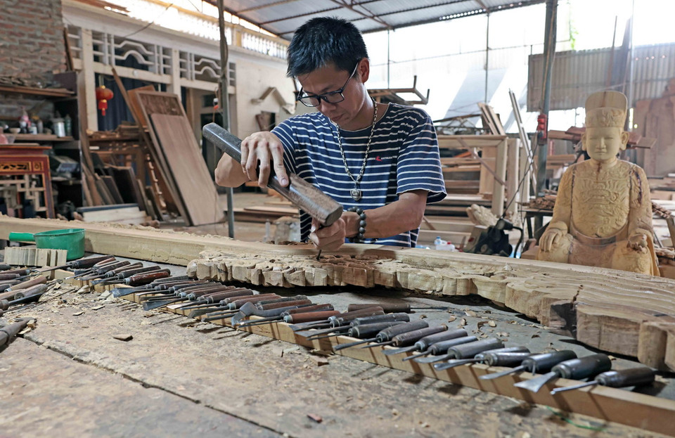 Nghệ nhân làng nghề Sơn Đồng với kỹ năng điêu luyện về chế tác các sản phẩm tâm linh. (Ảnh: Trần Việt/TTXVN)