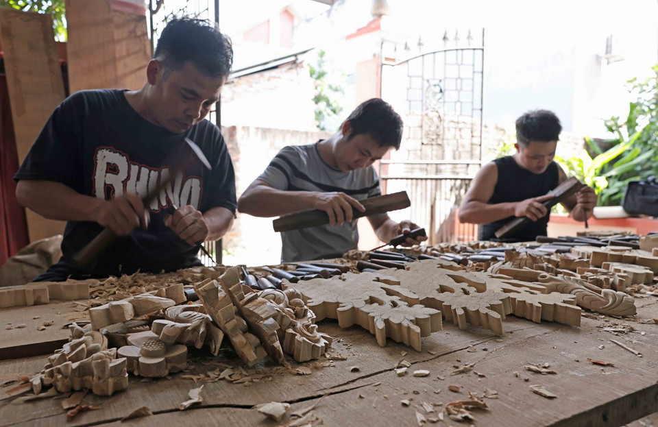 Kỹ thuật chạm trổ đồ thờ được các nghệ nhân trong làng truyền dạy từ đời này sang đời khác. (Ảnh: Trần Việt/TTXVN)