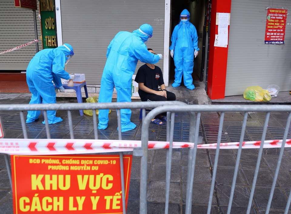 Người dân liên quan đến ca F0 ở số 21 Trần Nhân Tông được lấy mẫu xét nghiệm. (Ảnh: Hoàng Hiếu/TTXVN) 