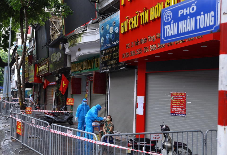 Liên quan đến ca F0 ở số 21 Trần Nhân Tông, nhân viên y tế lấy mẫu xét nghiệm cho người dân. (Ảnh: Hoàng Hiếu/TTXVN) 