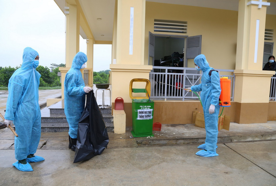 Lực lượng vệ sinh môi trường xung quanh khu vực cách ly nhằm hạn chế lây lan dịch bệnh. (Ảnh: Dương Giang/TTXVN)