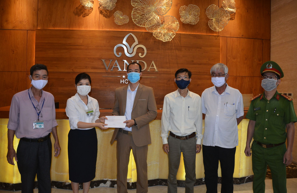 Đại diện phòng Y tế quận Hải Châu trao giấy hoàn thành cách ly cho đại diện khách sạn Vanda. (Ảnh: Văn Dũng/TTXVN)