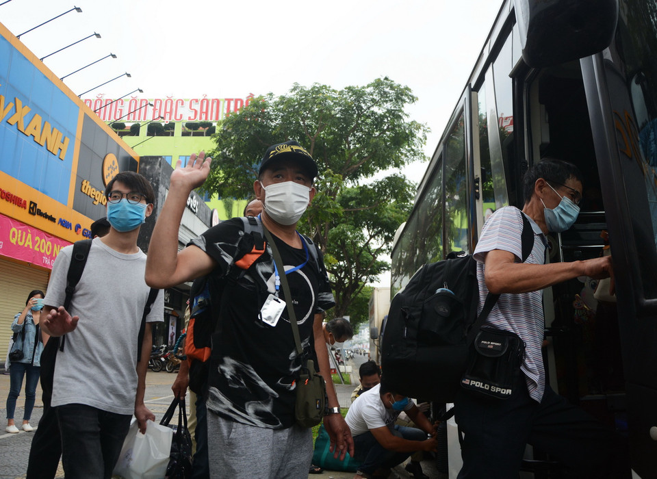 Du khách hoàn thành cách ly chào tạm biệt, lên xe ra sân bay trở về nước. (Ảnh: Văn Dũng/TTXVN)